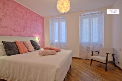 una camera da letto con un grande letto con una parete rosa di Casetta Mazzini a Rapallo