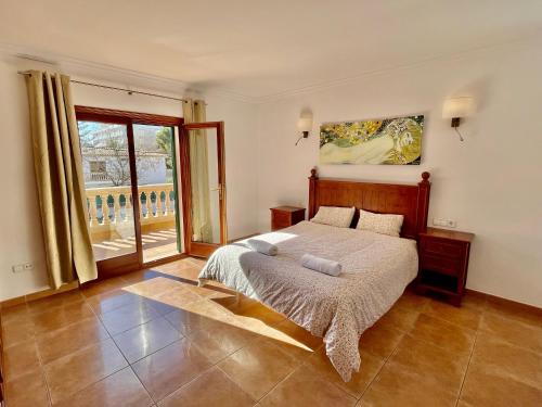 ein Schlafzimmer mit einem Bett und einem großen Fenster in der Unterkunft Can Jaume Ferienhaus an der Playa de Palma mit Pool in Palma de Mallorca