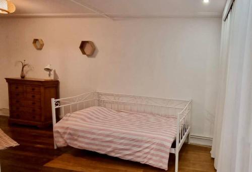 - une chambre avec un lit blanc et une commode dans l'établissement PERLE RARE, à Metz