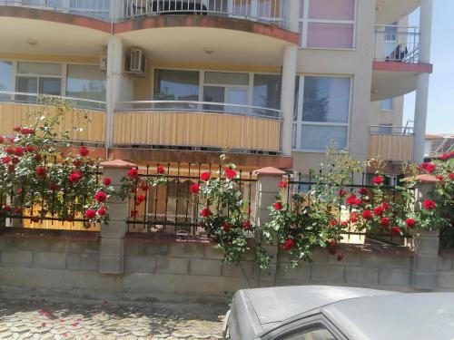 a building with red roses on a fence at Tedi in Kranevo