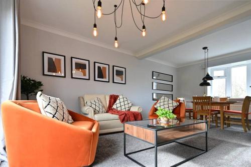 a living room with orange chairs and a table at Reduced rates for weekly, monthly and longer stays in Durham
