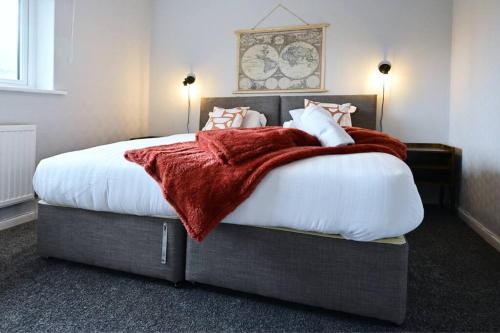 Un dormitorio con una cama grande con una manta roja. en Reduced rates for weekly, monthly and longer stays en Durham