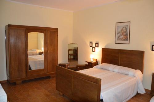 1 dormitorio con cama y espejo grande en B&B Domus De Janas, en Sedini