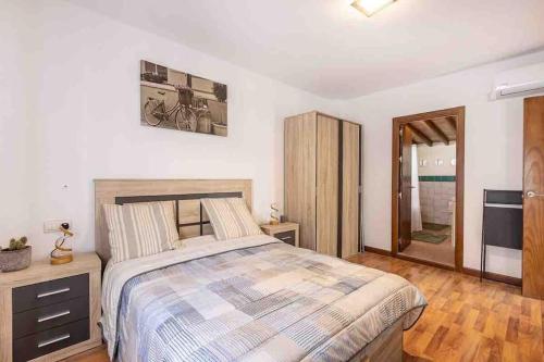 a bedroom with a large bed and a wooden floor at Entire house close to Albaicin and the city center in Granada