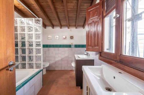 La salle de bains est pourvue de 2 lavabos, d'une baignoire et de toilettes. dans l'établissement Entire house close to Albaicin and the city center, à Grenade