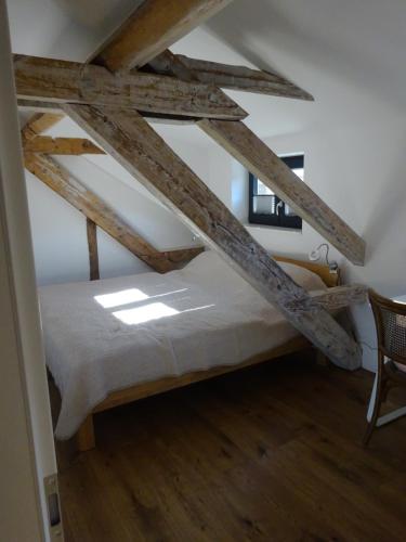 Ce lit se trouve dans un dortoir doté de poutres apparentes. dans l'établissement Exklusive, kernsanierte Ferienwohnung am Rursee, à Simmerath