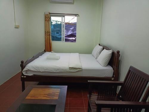 Cama en habitación con ventana y mesa en Kata S.T House 2 en Phuket