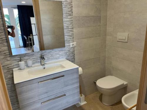 een badkamer met een wastafel, een toilet en een spiegel bij Residence Sei Delfini in Termoli
