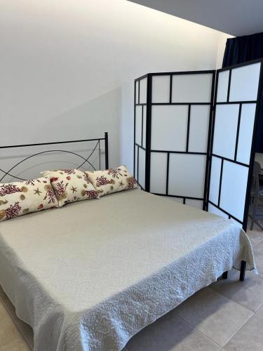 Una cama con marco negro y almohadas. en Residence Sei Delfini en Termoli
