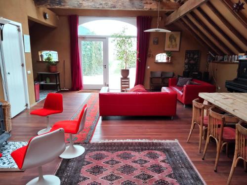 een woonkamer met rode meubels en een tafel bij Todo se pasa Yurt in Sauwerd