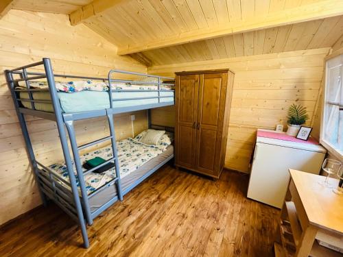 Zimmer mit Etagenbett und 2 Etagenbetten in einer Hütte in der Unterkunft Chatky Daniel-Mikulov, a private campsite just for you in Mikulov