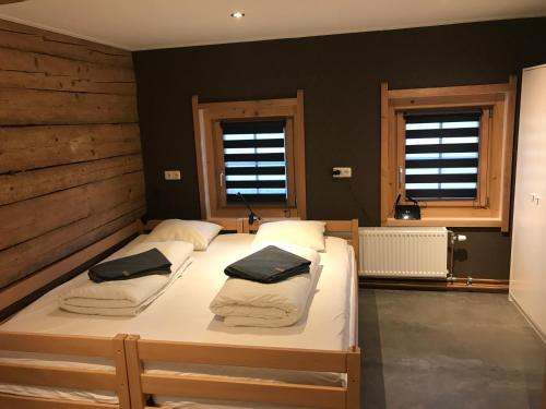 1 Schlafzimmer mit 2 Betten und 2 Fenstern in der Unterkunft The Farm in Westendorf