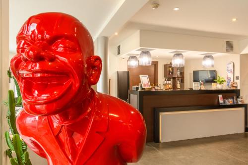 a red statue of a woman in a room at Hype Hôtel in Biscarrosse