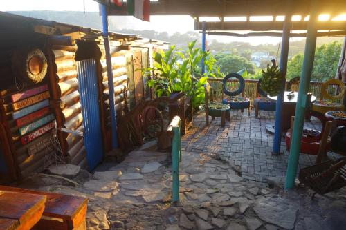 um pátio com cadeiras e mesas num edifício em Eagles Nest hostel plus self catering private units em Coffee Bay