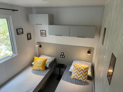 En eller flere senge i et værelse på Cocon du lac Mobilhome 3 chambres,6 pers,camping mayotte 5 étoiles Biscarrosse landes