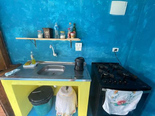 a small kitchen with a sink and a stove at Camping e Pousada do Ade in Ilha do Mel