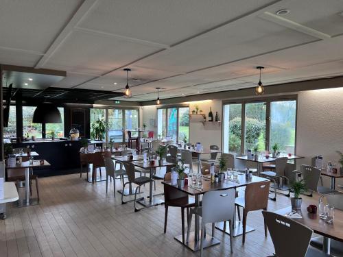 - une salle à manger avec des tables, des chaises et des fenêtres dans l'établissement Campanile Bordeaux Sud - Gradignan-Talence, à Gradignan