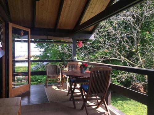 a wooden deck with a table and chairs on it at Le Fayard vue Lac in Publier