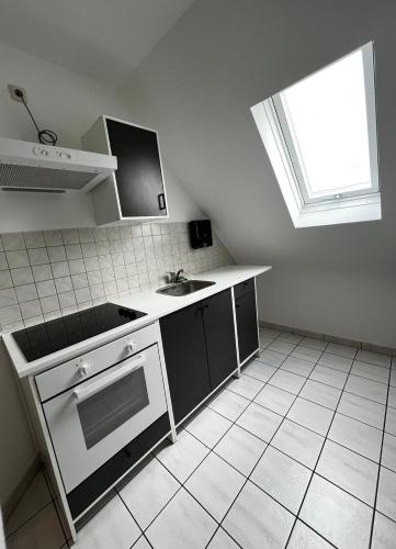 a kitchen with a stove and a sink and a window at Ferienwohnung Coburger Land, ländlich gut gelegen in Meeder