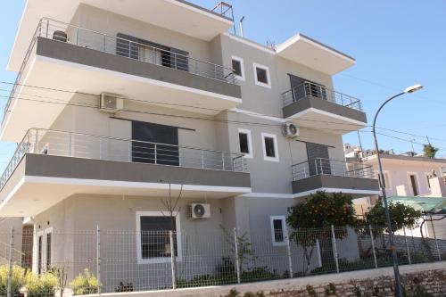 a white building with balconies on the side of it at Leva's Apartments in Sarandë