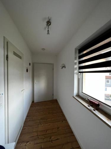 an empty room with a window and a hallway at Ferienwohnung Coburger Land, ländlich gut gelegen in Meeder