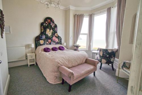 a bedroom with a large bed with purple pillows on it at Glan Y Mor Hotel (Adult Only) in Llandudno