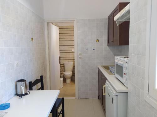 a small kitchen with a sink and a toilet at Sea Front Studios Old Town in Rethymno Town