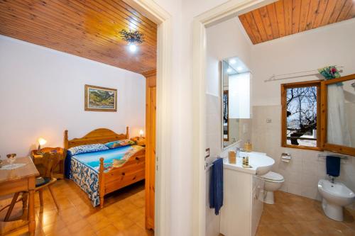a bedroom with a bed and a bathroom with a sink at Casa la noce Positano in Positano