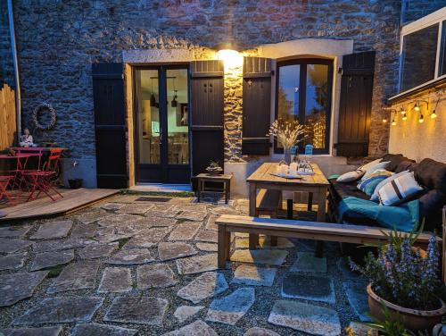d'une terrasse avec un canapé et une table en bois. dans l'établissement Quartier Saint-Enogat maison de charme proche des plages, à Dinard