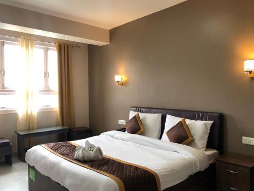 ein Schlafzimmer mit einem großen Bett in einem Zimmer in der Unterkunft ALL SEASONS HOTEL in Gangtok