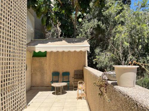 een patio met stoelen, een tafel en een muur bij לופט משגע במיקום מרכזי ברמת גן in Ramat Gan