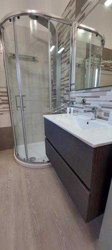bagno con doccia, lavandino e specchio di Sabrina's House a Porto Cesareo