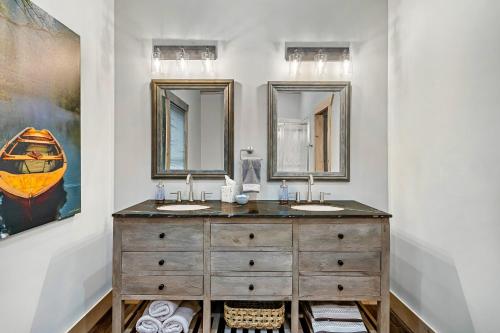 a bathroom with two sinks and two mirrors at New Luxury Vacation Home Cabin in Smoky Gatlinburg - Theater Room in Gatlinburg