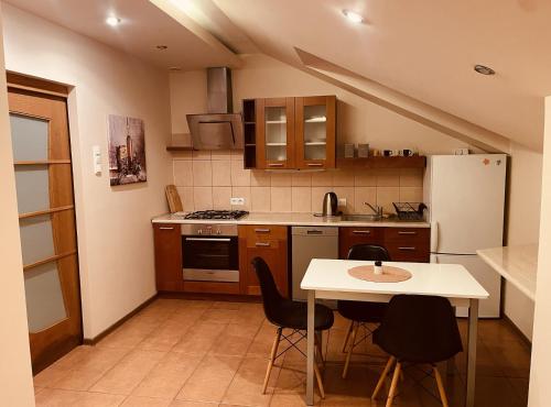 cocina con mesa, sillas y nevera en Apartament Słoneczny, en Ostrów Wielkopolski