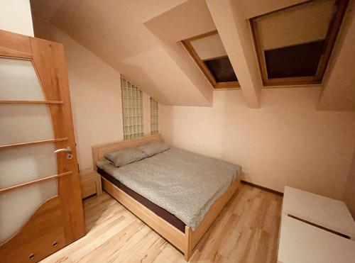 niewielka sypialnia z łóżkiem i oknem w obiekcie Apartament Słoneczny w Ostrowie Wielkopolskim