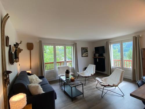 拉克呂薩的住宿－Les bouquetins，客厅配有蓝色的沙发和白色的椅子