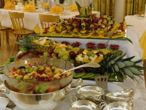 a buffet of fruits and vegetables on a table at Hotel Pontechiesa in Cortina dʼAmpezzo