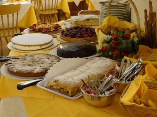 a table with many different types of cakes and pies at Hotel Pontechiesa in Cortina dʼAmpezzo