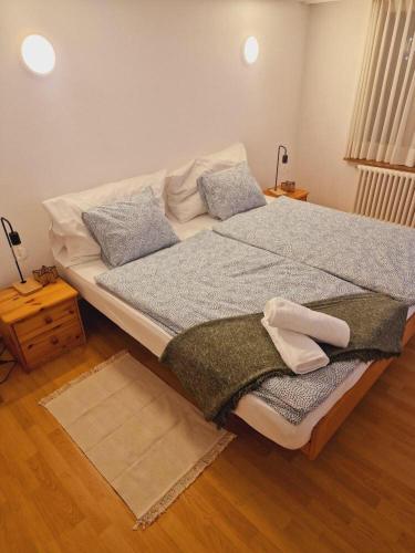 ein großes Bett in einem Zimmer mit Holzboden in der Unterkunft Sehr ruhiger Ort in Ebnat