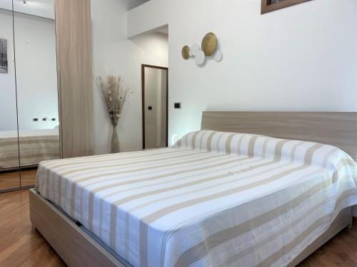 1 dormitorio con 1 cama con colchón a rayas en Appartamento S Giuliano Mse Piazza Brivio, en San Giuliano Milanese