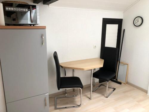 a small table and chairs in a kitchen with a clock at Felsenblick in Rodalben