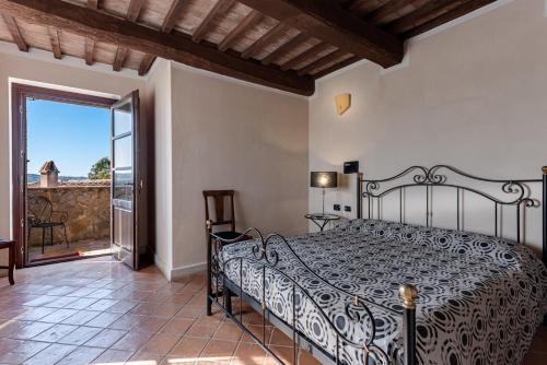 a bedroom with a bed and a balcony at Relais Le Ginestre in Saturnia