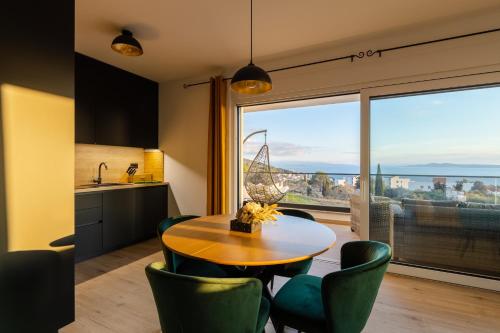 a kitchen with a table and chairs and a large window at Apartment Dado in Trogir