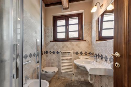 a bathroom with a toilet and a sink and a shower at Relais Le Ginestre in Saturnia