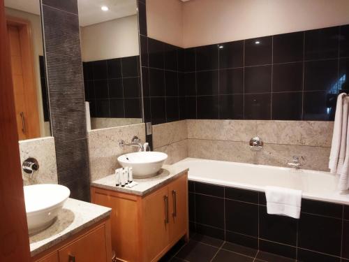 a bathroom with two sinks and a bath tub and a sink at Michelangelo Towers 718 in Johannesburg