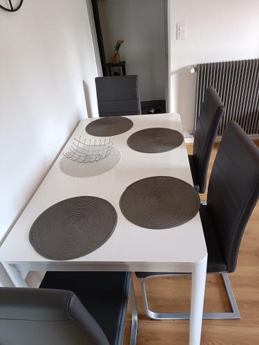une table avec quatre chaises et une table blanche avec des cercles dessus dans l'établissement Super appartement 6 voyageurs hyper centre, à Montluçon