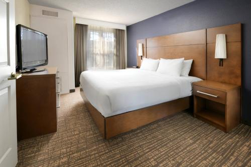 ein Hotelzimmer mit einem großen Bett und einem Flachbild-TV in der Unterkunft Residence Inn Houston Westchase On Westheimer in Houston