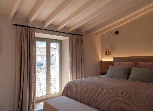 a bedroom with a bed and a large window at Can Verí Suites in Sóller