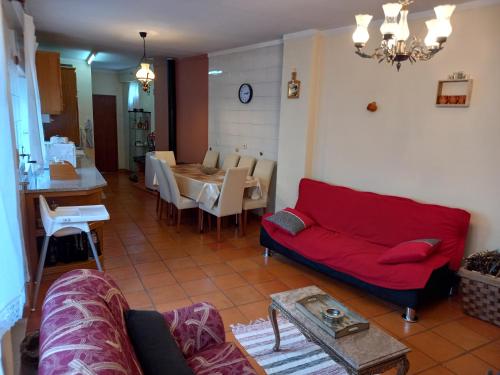 a living room with a red couch and a table at Casa da Ribeira em Rabal in Rabal