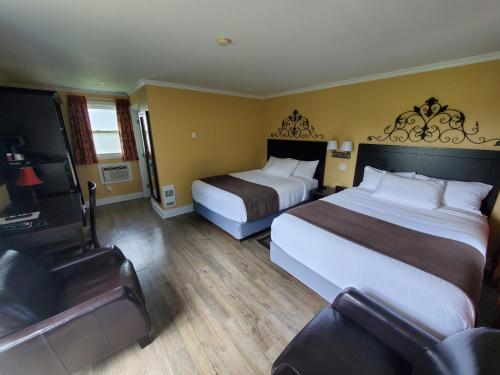 um quarto de hotel com duas camas e uma televisão em Sunny Isle Motel em Summerside